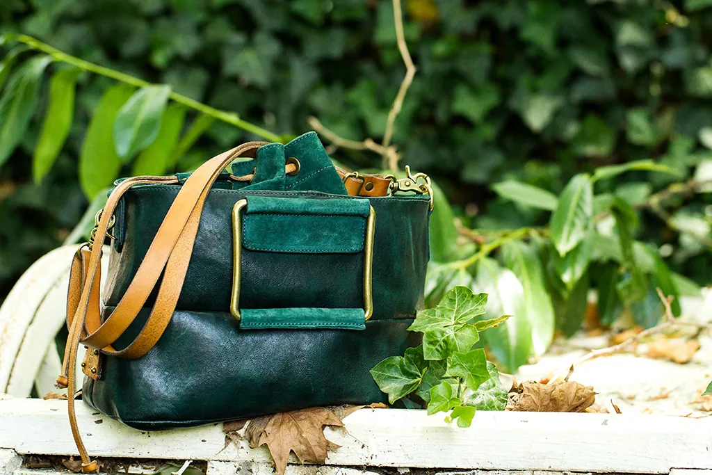 Borsa verde smeraldo tra le foglie