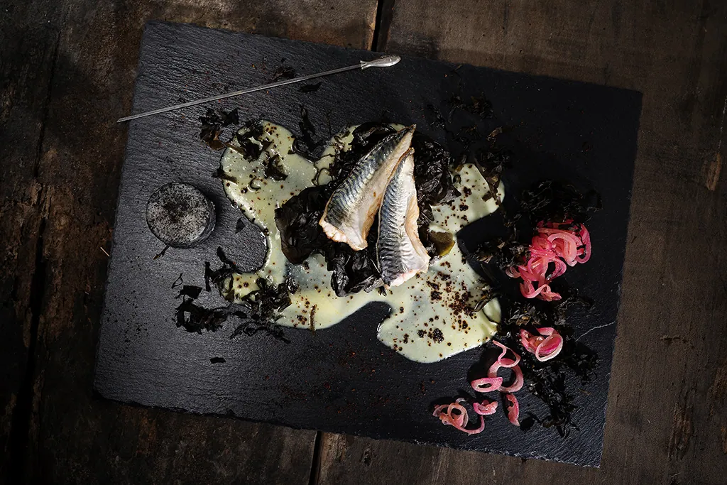 Piatto di pesce su ardesia nera